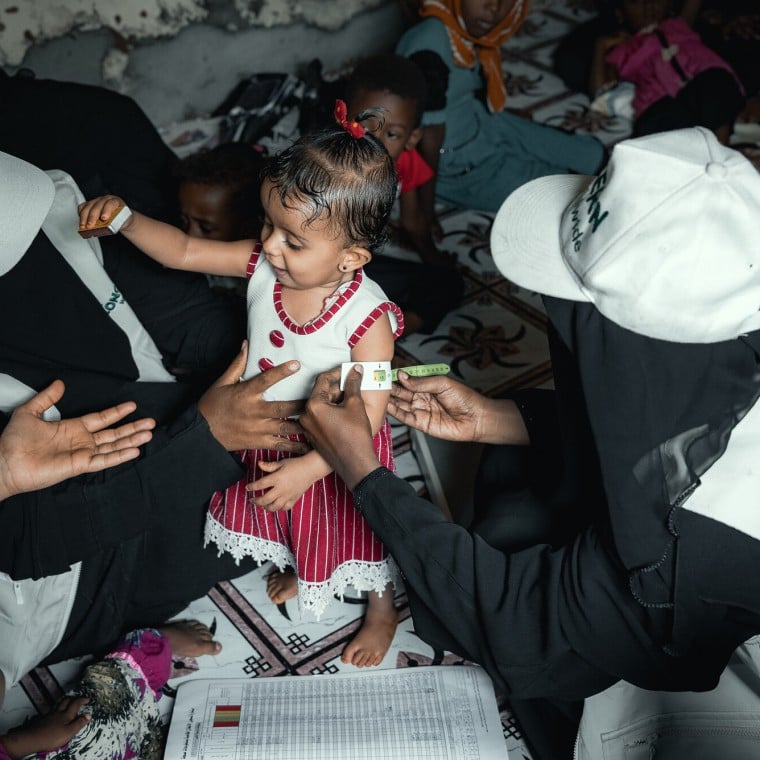 Community Health Volunteer (CHVs) conducting nutrition screening on a child in Yemen.