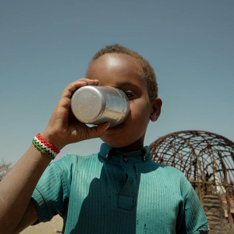 Muhktar drinks from a cup of water