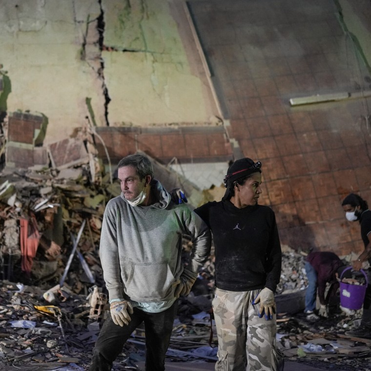 People stand at the site of a collapsed building following an earthquake in Caracas on June 25, 2026