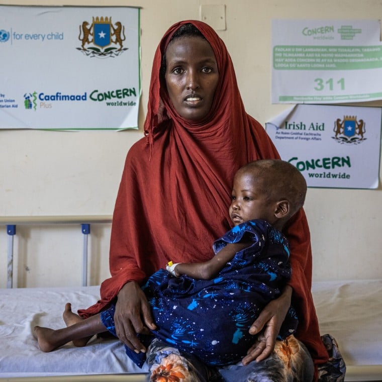 Faizah holding her daughter Malliya in health centre